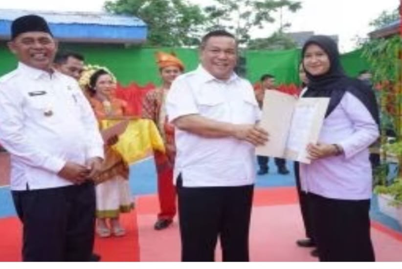 Penjabat Gubernur Riau SF Hariyanto Pohan memberikan hadiah umroh kepada Heri Yulindo, guru dari kampung Syamsuar