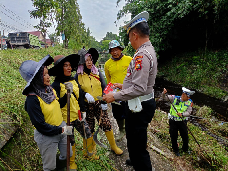 Sembari Gotong Royong Personil Ditlantas Polda Riau Sampaikan Pesan Kamseltibcarlantas dan Pemilu Damai.